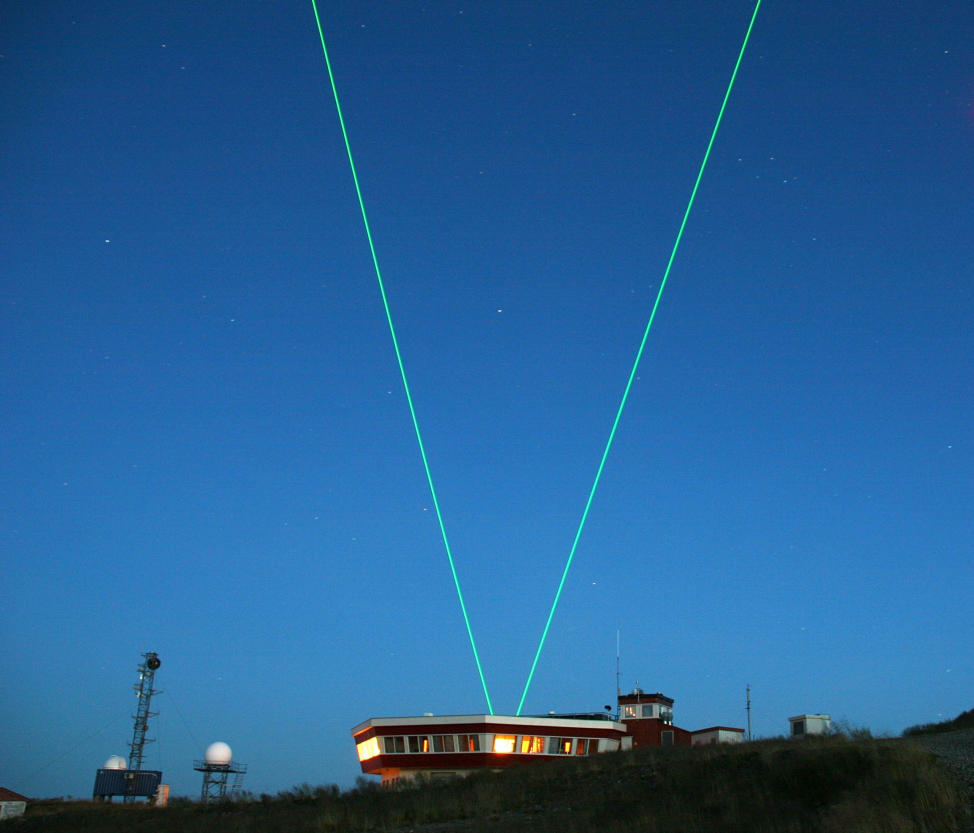 Fig. 1:ALOMAR observatory and laser beams of the ALOMAR RMR-lidar during operation with tilted telescopes (courtesy, J. Fiedler)